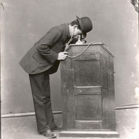 Hombre mirando un kinetoscopio equipado con-sonido sincronizado ©U.S.-Dept. of the Interior,-National Park Service,-Thomas Edison