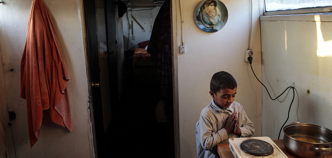 Marus, de 7 años, se calienta las manos junto a una estufa portátil antes de ir a la escuela el día del desalojo de su remolque en Las Tablas, norte de Madrid, el 21 de marzo de 2011. Dos familias gitanas rumanas de cuatro adultos y diez niños vivían en el remolque desde 2008, pero fueron desalojados el lunes por orden de la junta de urbanismo de Madrid. Su casa fue derribado mientras los niños mayores estaban en la escuela. REUTERS/Susana Vera